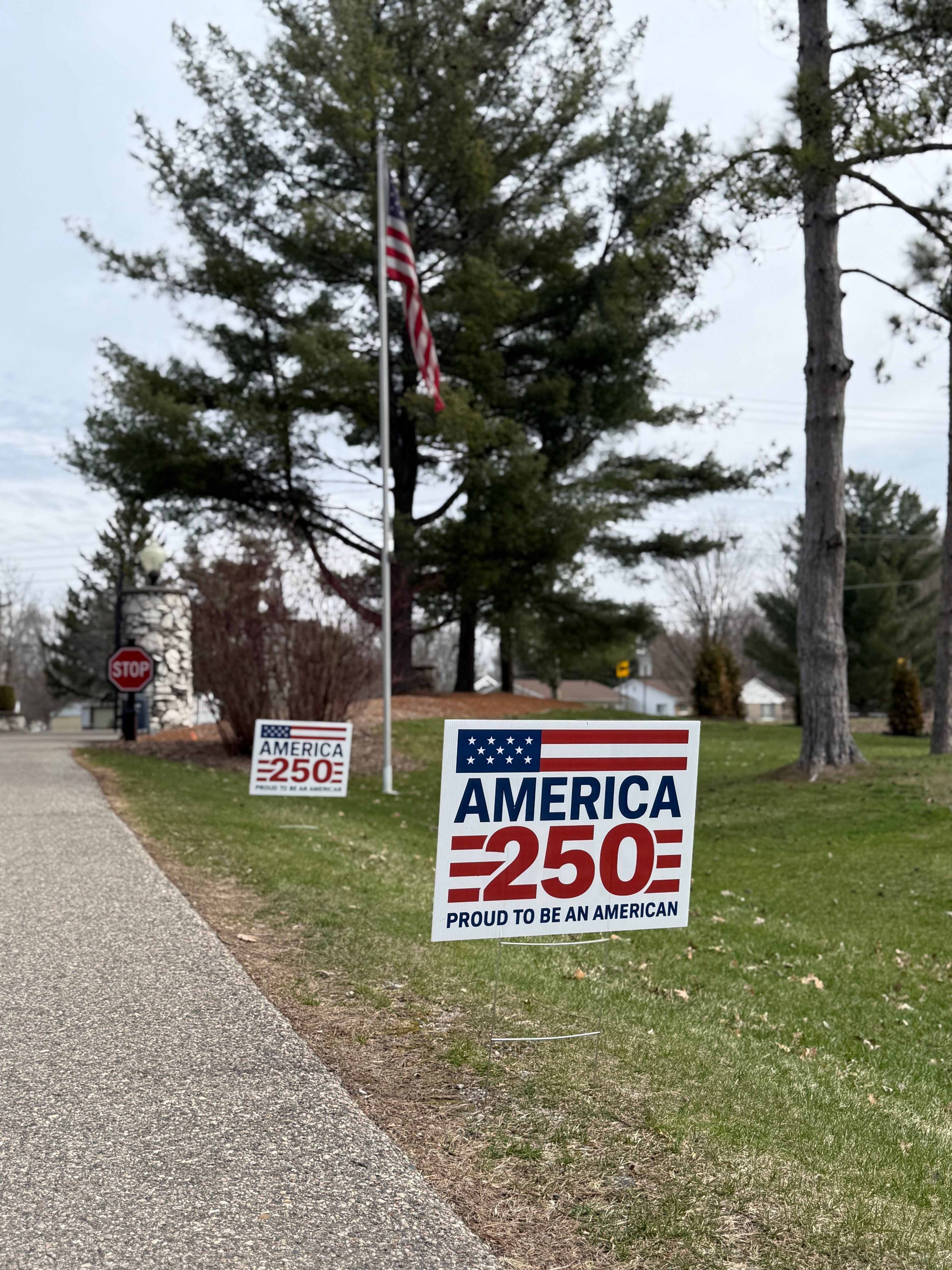 America 250 Proud to Be American Yard Sign Flag design at neighborhood entrance
